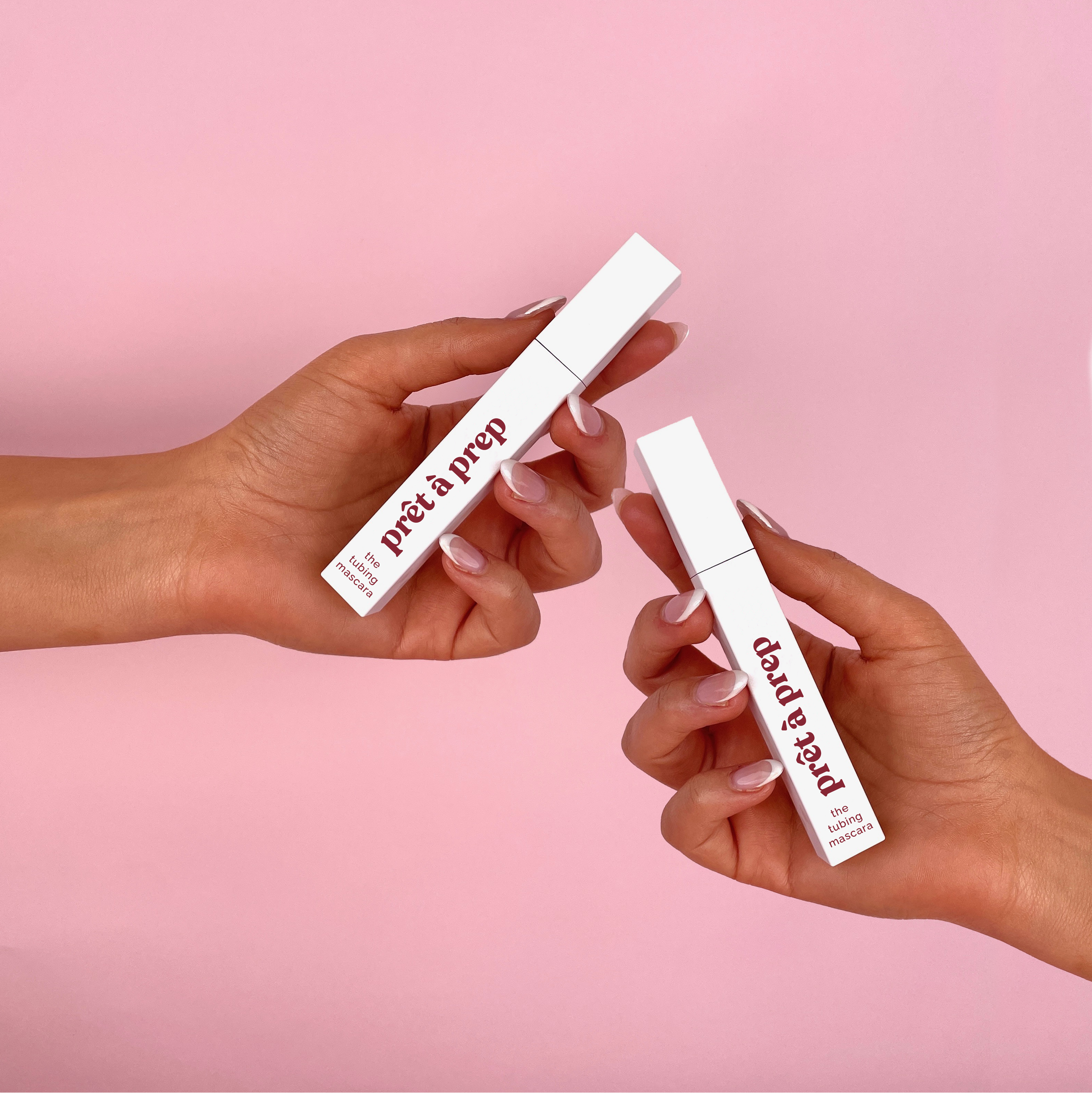 Two hands holding 'pret a prep' and products against a pink background